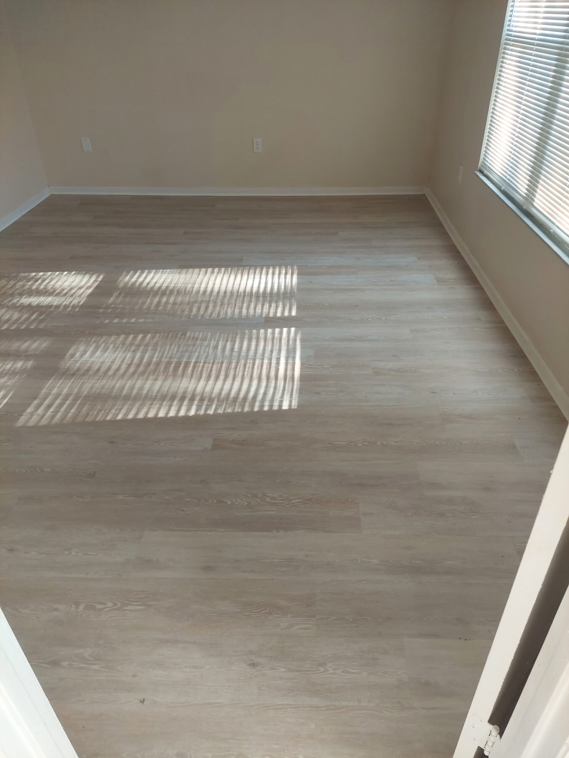 Close-up of professionally installed luxury vinyl tile (LVT) flooring with realistic wood-look texture.